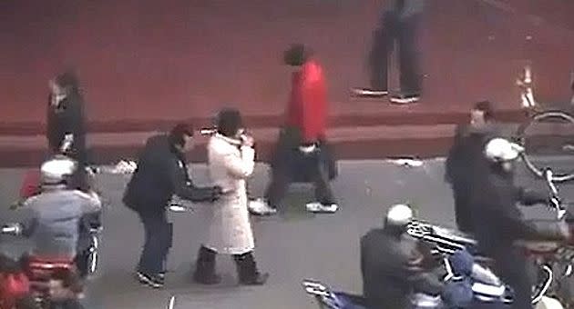 Passers-by refuse to intervene as a man uses his chopstick to rob a woman in broad daylight. Photo: YouTube.