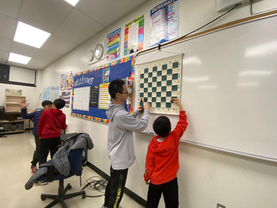 Grade 9 student Johnathan Han teaches younger kids chess at a Kanata, Ont. high school.