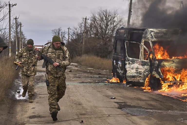 Soldados ucranianos pasan junto a un ómnibus de voluntarios en llamas después de que un dron ruso lo impactara cerca de Bakhmut, región de Donetsk, Ucrania (Shandyba Mykyta, Ukrainian 10th Mountain Assault Brigade 