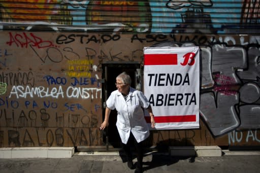 Some shops in Valparaiso have "Store Open" signs, but they are still boarded up or leave their security screens down, forcing customers to enter through small openings