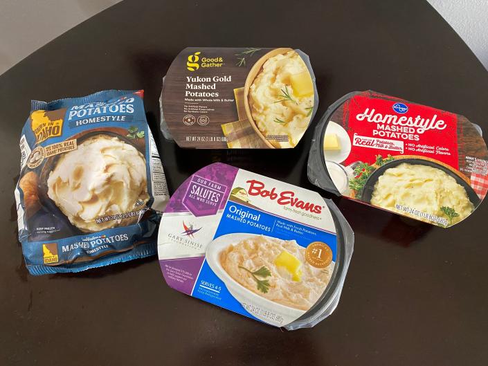 four packages of different brands of premade mashed potatoes