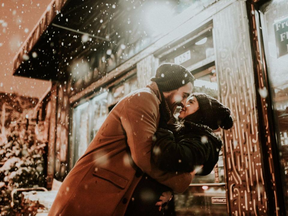 couple snow winter smiling hug