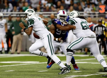 Nov 24, 2014; Detroit, MI, USA; New York Jets quarterback Geno Smith (7) is chased out of the pocket under pressure by Buffalo Bills defensive tackle Marcell Dareus (99) during the second half at Ford Field. Bills beat the Jets 38-3. Mandatory Credit: Kevin Hoffman-USA TODAY Sports