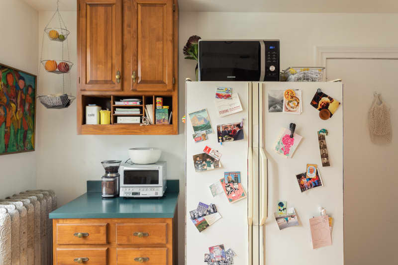 A small kitchen with a microwave on refrigerator.