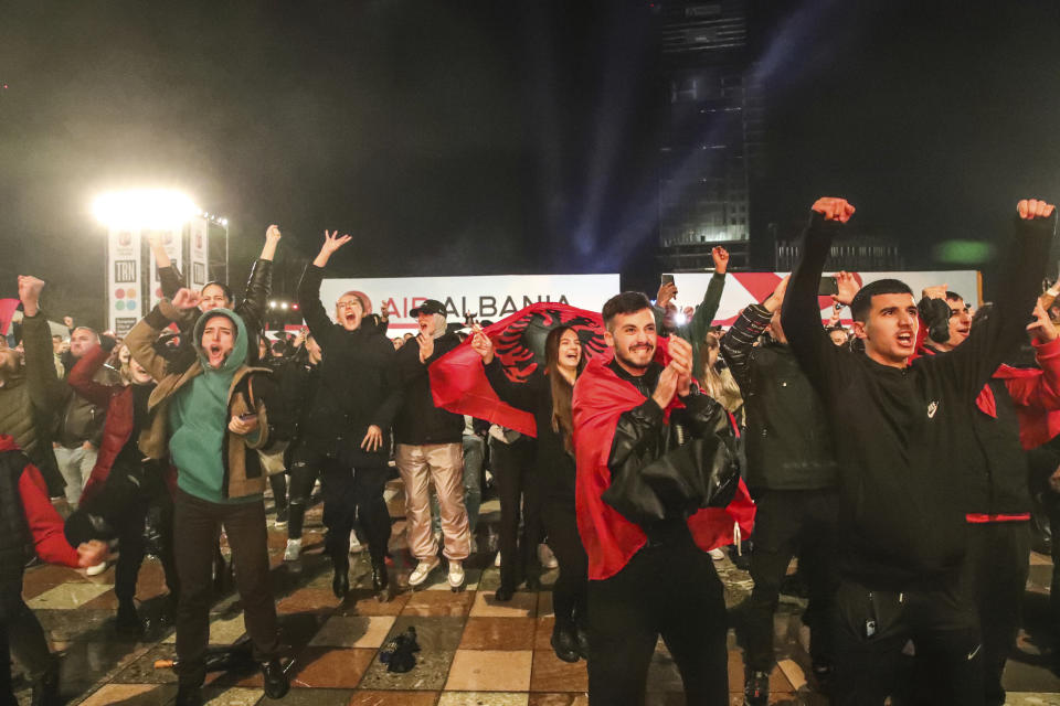Albanian fans react as they watch on a giant screen, the Euro 2024 group E qualifying soccer match between Moldova and Albania at Skanderbeg square, in Tirana, Albania, Friday, Nov. 17. 2023. The match ended 1-1 and the national team qualified for the Euro 2024 in Germany. (AP Photo/Armando Babani)