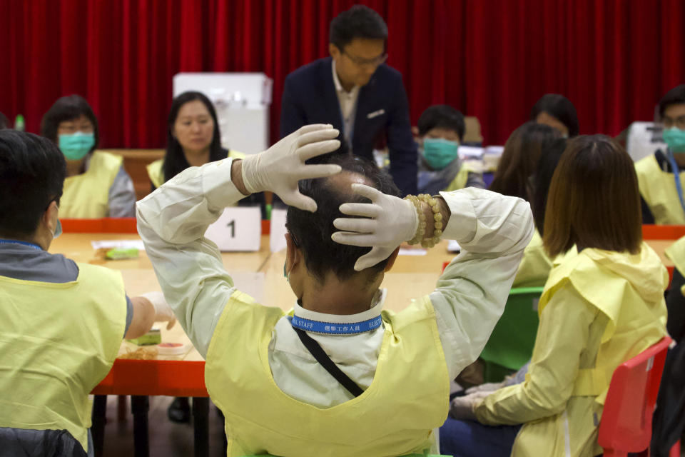 FILE -0 An election worker reacts after sorting through ballots at a polling station in Hong Kong, Nov. 25, 2019. Hong Kong's leader on Tuesday, May 2, 2023, stepped up a campaign to shut down democratic challenges by unveiling plans to eliminate most directly elected seats on local district councils, the last major political representative bodies mostly chosen by the public. (AP Photo/Ng Han Guan, File)