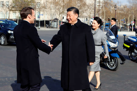 French President Emmanuel Macron greets his Chinese counterpart Xi Jinping and his wife Peng Liyuan as they arrive at the Arc de Triomphe monument to attend a wreath laying ceremony, in Paris, France March 25, 2019. Francois Mori/Pool via REUTERS