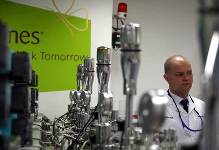 A worker for the Danish biopharmaceutical company Novozymes stands next to fermentation vates for producing enzymes at a factory in Beijing, China, May 24, 2011. REUTERS/David Gray/File Photo