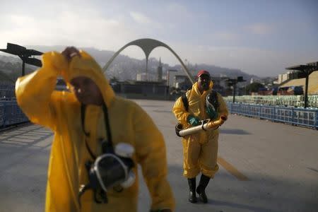 Municipal workers walk after spraying insecticide at Sambodrome in Rio de Janeiro, Brazil, January 26, 2016. REUTERS/Pilar Olivares