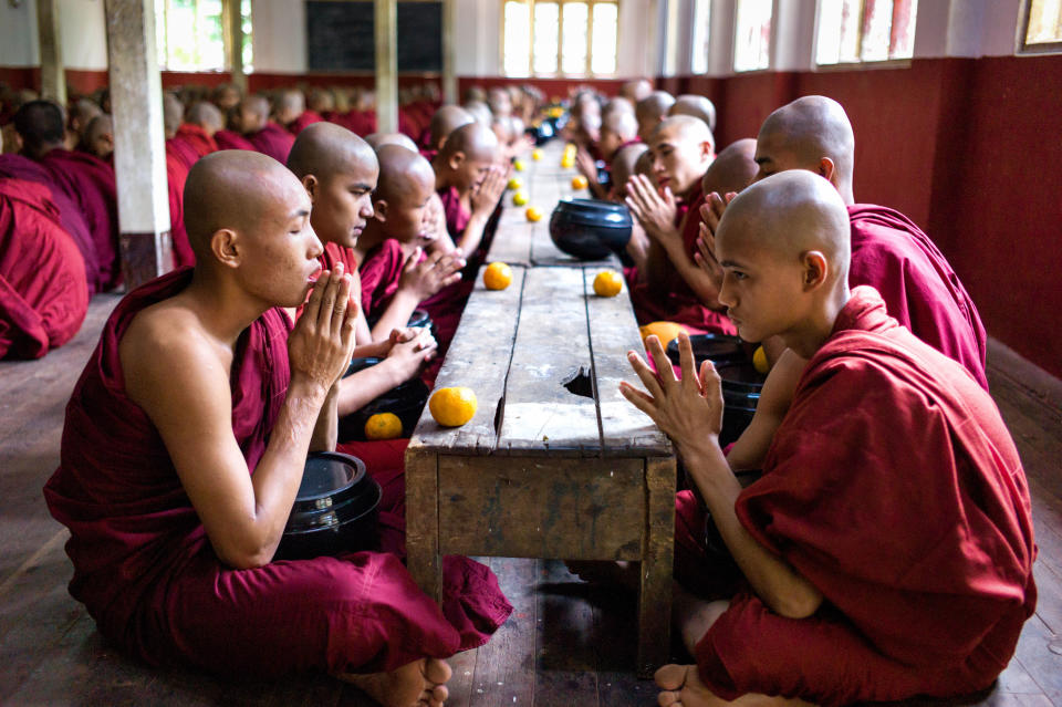 In this December 2012 photo monks pray before eating at the Buddhist Kaleywatawye Monastery in Yangon, Myanmar. (AP Photo/Richard Camp)