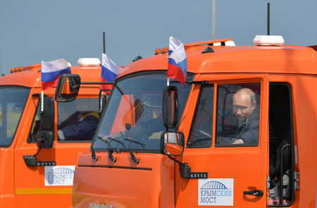 Russian President Vladimir Putin closes the door of a Kamaz truck during a ceremony opening a bridge, which was constructed to connect the Russian mainland with the Crimean Peninsula, near the Taman Peninsula in Krasnodar Region, Russia May 15, 2018. Sputnik/Alexei Druzhinin/Kremlin via REUTERS