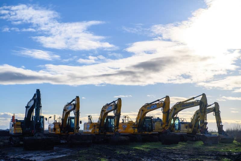 Excavators stand side by side at the edge of a field. The chip company Intel is putting the construction of a factory in Magdeburg on hold. The project will probably be delayed by two years, announced company boss Gelsinger. Intel is struggling with losses and has initiated a cost-cutting program. Klaus-Dietmar Gabbert/dpa