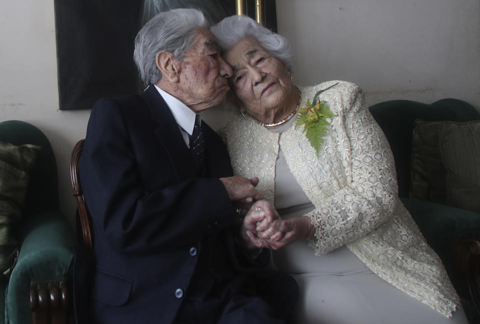 Los esposos Julio Mora Tapia, de 110 años, Waldramina Quinteros, de 104, ambos profesores retirados, posan para una foto en su hogar en Quito, Ecuador, el viernes 28 de agosto de 2020. (AP Foto/Dolores Ochoa)