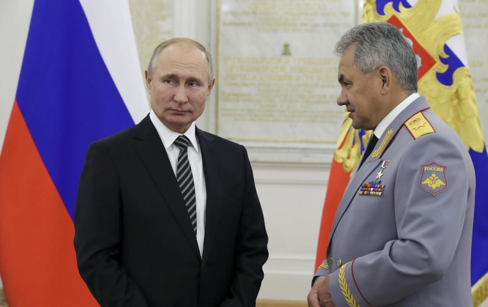 Russian President Vladimir Putin, left, listens to Defense Minister Sergei Shoigu during a meeting with senior military officers in Moscow, Russia, Wednesday, Nov. 6, 2019. Putin said Russia's new weapons have no foreign equivalents but he insists the country will not use them to threaten anyone. (Mikhail Klimentyev, Sputnik, Kremlin Pool Photo via AP)