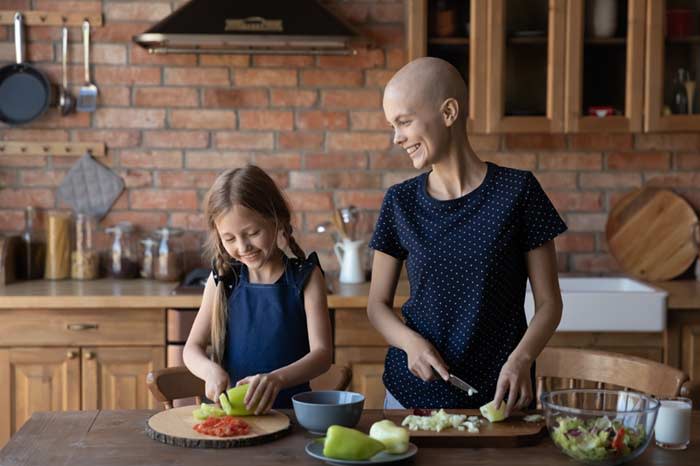 mujer en tratamiento de cáncer cocinando