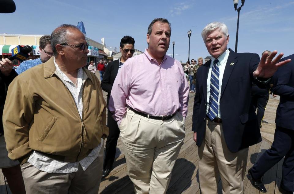 Seaside Park Mayor Robert Matthies, right, points in the direction of the reconstruction of his town's beach-front boardwalk while walking with New Jersey Gov. Chris Christie, center, and Seaside Heights Mayor William Akers, Friday, April 25, 2014, in Seaside Heights, N.J. Christie visited the boardwalk to see progress following last September's massive fire that burned down the Seaside Park side of the boardwalk. Previously, the boardwalk had been rebuilt following Superstorm Sandy. Investigators determined the fire started in wiring under the boardwalk in Seaside Park that had been damaged by exposure to storm water from Sandy. (AP Photo/Julio Cortez)