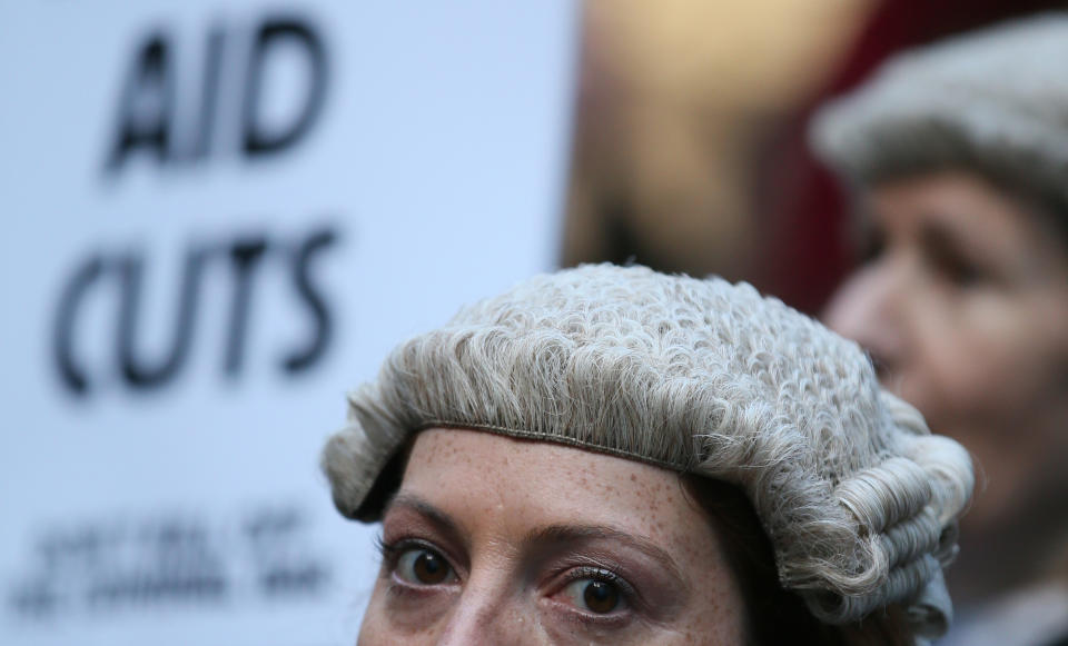 Lawyer Alice Jarratt takes part in a protest outside Southwark Crown Court during a demonstration against cuts to legal aid funding, in London, Monday, Jan. 6, 2014. Hundreds of British lawyers, many dressed in traditional wigs and gowns, have swapped courtrooms for picket lines to protest planned cuts to legal-aid funding. Hearings were disrupted Monday at courts including London’s famous Old Bailey as barristers staged their first-ever national walkout. The British government, which has slashed spending in the name of deficit reduction, plans to cut lawyers’ fees in a bid to reduce the legal aid budget by 220 million pounds ($360 million) by 2019. (AP Photo/Alastair Grant)