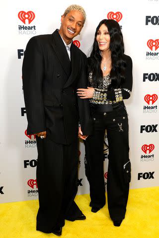 <p>Frazer Harrison/Getty </p> Alexander "AE" Edwards and girlfriend Cher, winner of the Icon award, pose in the press room during the 2024 iHeartRadio Music Awards in Los Angeles on April 1, 2024