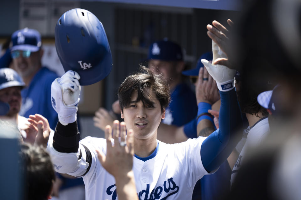 Los Angeles Dodgers' Shohei Ohtani celebrates after his two-run home run in the dugout during the third inning of a baseball game against the New York Mets in Los Angeles, Sunday, April 21, 2024. (AP Photo/Kyusung Gong)