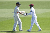 West Indies Jermaine Blackwood, left, shakes hands with New Zealand's Kane Williamson at the close of the New Zealand innings during play on day two of the first cricket test between the West Indies and New Zealand in Hamilton, New Zealand, Friday, Dec. 4, 2020. (Andrew Cornaga/Photosport via AP)