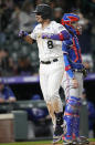 Colorado Rockies'' Joshua Fuentes celebrates as he crosses home plate after hitting a solo home run, next to Texas Rangers catcher Jonah Heim during the eighth inning of a baseball game Wednesday, June 2, 2021, in Denver. (AP Photo/David Zalubowski)