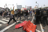 A protester prepares to throw a brick at police trying to stop a rally from advancing towards the Presidential Palace in Jakarta, Indonesia, Thursday, Oct. 8, 2020. Thousands of enraged students and workers staged rallies across Indonesia on Thursday in opposition to a new law they say will cripple labor rights and harm the environment. (AP Photo/Achmad Ibrahim)