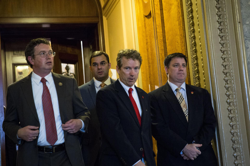 Rep. Thomas Massie (R-Ky.), left, and Sen. Rand Paul (R-Ky.), center, exit the Senate floor after Paul spoke about surveillance legislation on Capitol Hill on May 31, 2015.