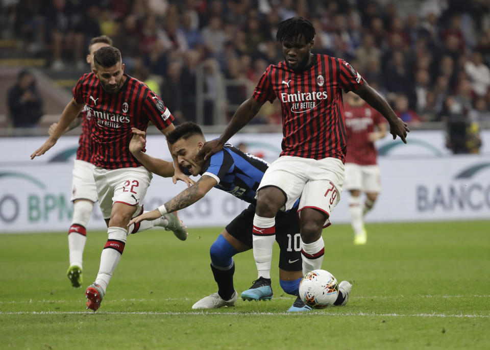 Inter Milan's Lautaro Martinez, centre, is mould by AC Milan's Franck Kessie, right, and AC Milan's Mateo Musacchio during a Serie A soccer match between AC Milan and Inter Milan, at the San Siro stadium in Milan, Italy, Saturday, Sept.21, 2019. (AP Photo/Luca Bruno)