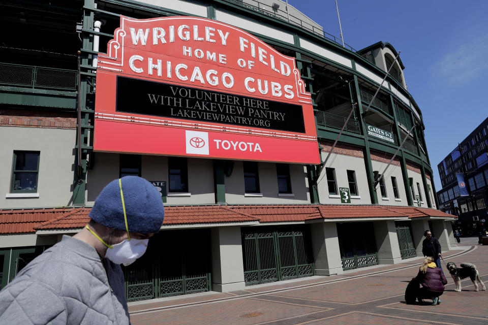 FILE - In this April 16, 2020, file photo, Wrigley Field's marquee displays Lakeview Pantry volunteer information in Chicago. With no games being played, recent sports headlines have centered around hopes and dreams — namely, the uncharted path leagues and teams must navigate to return to competition in the wake of the pandemic. (AP Photo/Nam Y. Huh, File)