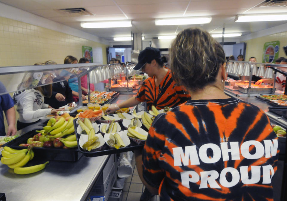 Michel Sasso, front and Maria Frisone restock food items along the lunch line of the cafeteria at Draper Middle School in Rotterdam, N.Y., Tuesday, Sept. 11, 2012. The leaner, greener school lunches served under new federal standards are getting mixed grades from students. (AP Photo/Hans Pennink)
