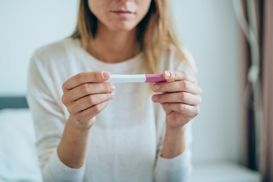 A woman reads the result of a pregnancy test