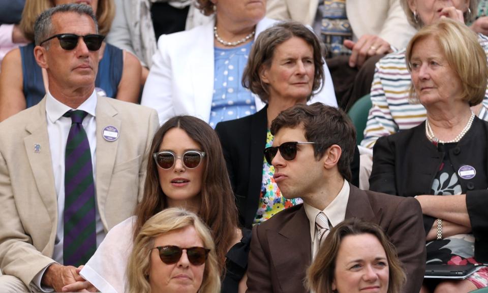 Keira Knightley and James Righton chat from the royal box as Knightley stays focused on the game.