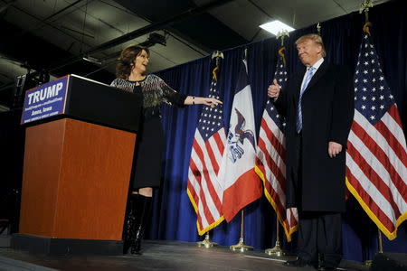 Former Alaska Gov. Sarah Palin (L) points to U.S. Republican presidential candidate Donald Trump (R) as she speaks after endorsing him for President at a rally at Iowa State University in Ames, Iowa January 19, 2016. REUTERS/Mark Kauzlarich