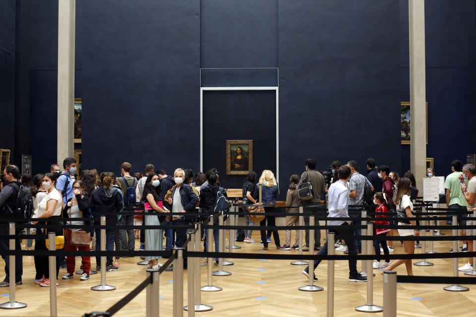 Visitors wait to see the Leonardo da Vinci's painting Mona Lisa, in Paris, Monday, July 6, 2020. The home of the world's most famous portrait, the Louvre Museum in Paris, reopened Monday after a four-month coronavirus lockdown. (AP Photo/ Thibault Camus)