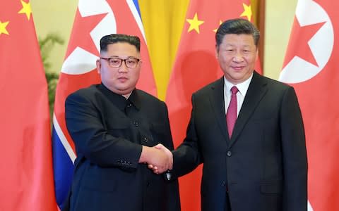North Korean leader Kim Jong Un (L) shaking hands with Chinese President Xi Jinping at the Great Hall of the People in Beijing. - Credit: KCNA/AFP