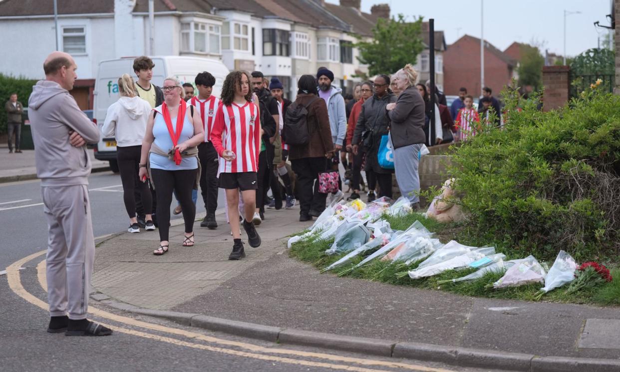 <span>Members of the community visit floral tributes to Daniel Anjorin in a street in Hainault, London. </span><span>Photograph: Yui Mok/PA</span>