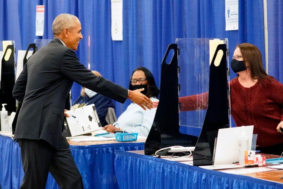 Mandatory Credit: Photo by Charles Rex Arbogast/AP/Shutterstock (13473189d) Former President Barack Obama shakes hands with a poll worker before casting his ballot at an early voting site, in Chicago Obama Early Voting , Chicago, United States - 17 Oct 2022