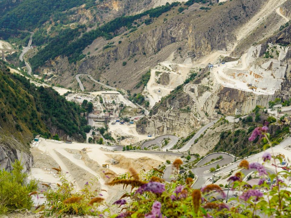 A wide view of a marble mountain range dotted with quarries