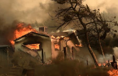 Flames from the Erskine Fire engulf a home near Weldon, California, U.S. June 24, 2016. REUTERS/Noah Berger