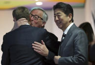 Japan's Prime Minister Shinzo Abe, right, waits as European Commission President Jean-Claude Juncker, center, greets European Council President Donald Tusk during an EU-Japan summit at the European Council building in Brussels, Thursday, April 25, 2019. Japanese Prime Minister Shinzo Abe and top EU officials are discussing trade, bilateral ties and North Korea. (AP Photo/Francisco Seco, Pool)