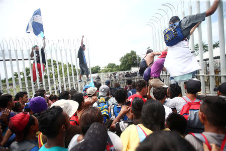 Honduran migrants, part of a caravan trying to reach the U.S., storm a border checkpoint, in Ciudad Hidalgo, Mexico October 19, 2018. REUTERS/Edgard Garrido