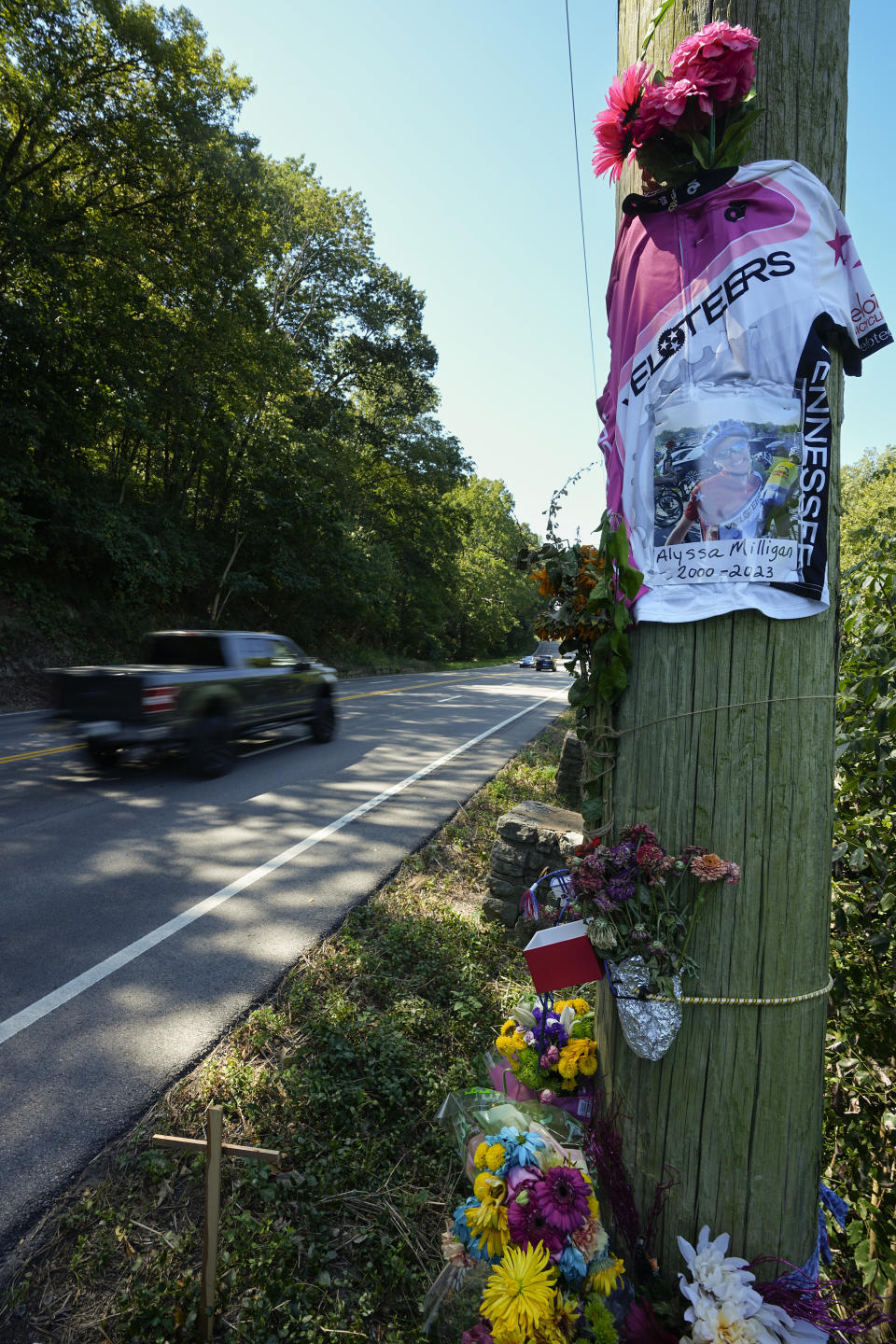 A roadside memorial for cyclist Alyssa Milligan is seen along state Highway 100 near Percy Warner Park, Friday, Sept. 15, 2023, in Nashville, Tenn. Milligan was struck and killed by a pickup truck near the site while riding with a friend the previous week. (AP Photo/George Walker IV)