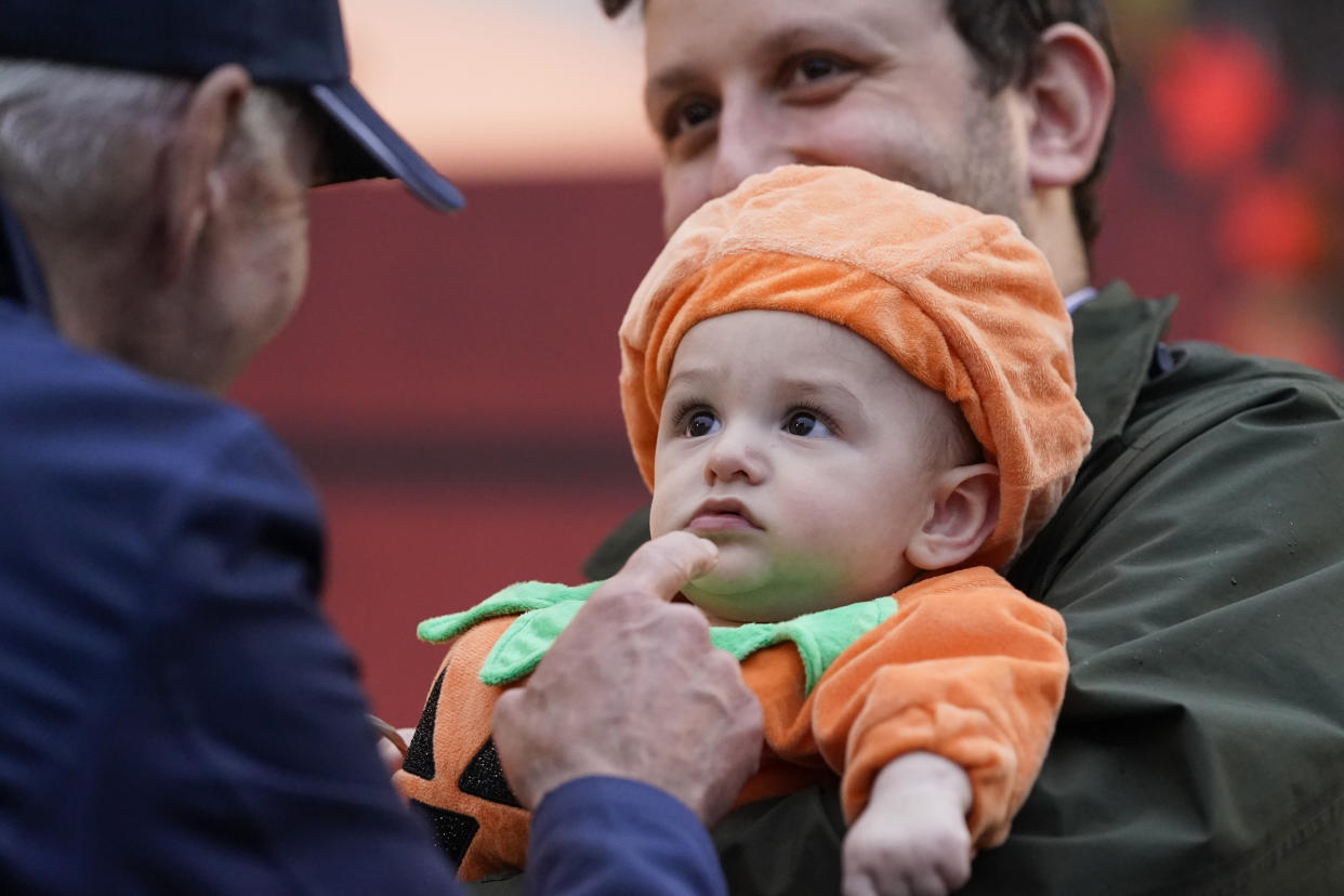 President Joe Biden gestures to a young child as he gives treats to trick-or-treaters on the South Lawn of the White House, on Halloween, Monday, Oct. 31, 2022, in Washington. (AP Photo/Alex Brandon)