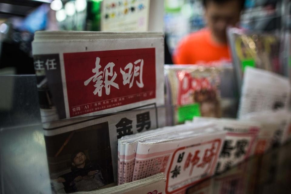 A copy of Hong Kong based newspaper Ming Pao (top L) is displayed at a convenience store in Hong Kong on December 17, 2015. Shares in the owner of Hong Kong-based newspaper Ming Pao shot up on December 17 on rumours that Chinese Internet giant Alibaba was in talks to buy it, days after it snapped up the city's South China Morning Post. AFP PHOTO / ANTHONY WALLACE / AFP / ANTHONY WALLACE        (Photo credit should read ANTHONY WALLACE/AFP via Getty Images)