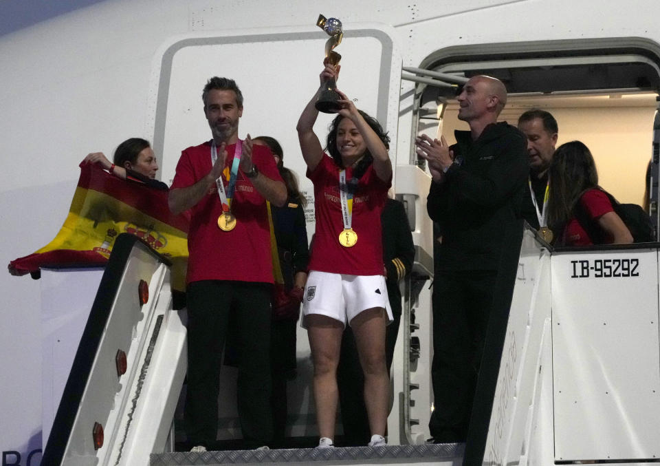 Spain's Ivana Andres lifts the trophy with other members of the Spain's Women's World Cup soccer team as they arrive at Barajas international airport in Madrid, Spain, Monday, Aug. 21, 2023. Spain beat England in Sydney Sunday to win the Women's World Cup soccer final. (AP Photo/Paul White)