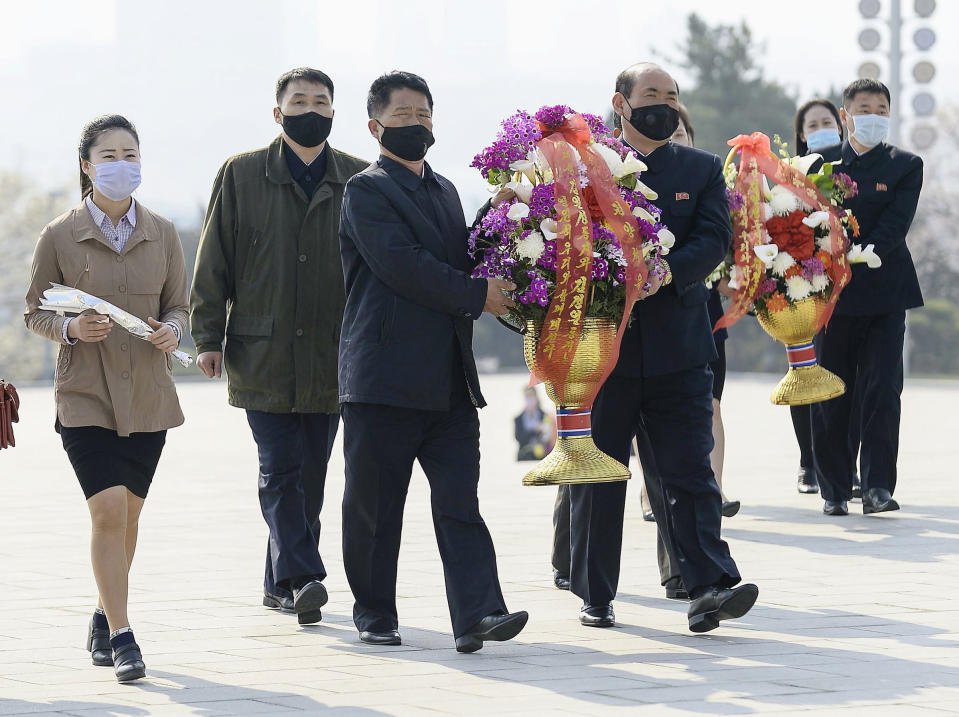 North Koreans wearing masks visit offer flowers on the 108th anniversary of the birth Kim Il Sung. Source: AAP