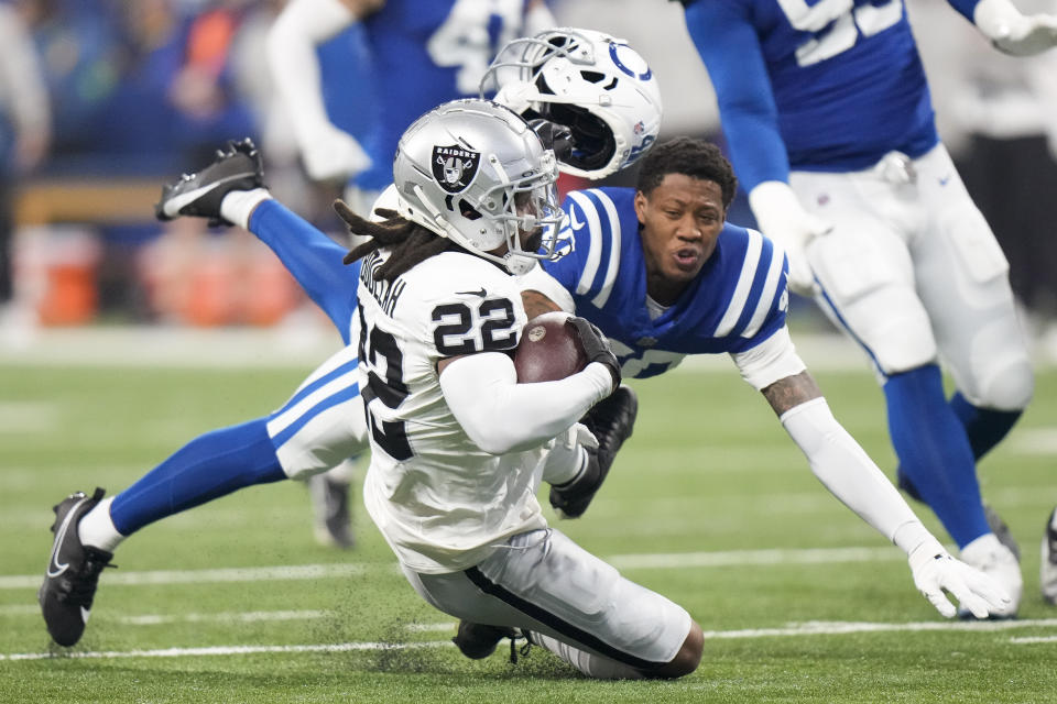 Indianapolis Colts cornerback Jaylon Jones (40) loses his helmet as he tackles Las Vegas Raiders running back Ameer Abdullah (22) during the first half of an NFL football game Sunday, Dec. 31, 2023, in Indianapolis. (AP Photo/AJ Mast)