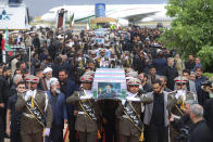 In this photo released by the Iranian Presidency Office, army members carry the flag-draped coffins of President Ebrahim Raisi and his companions who were killed in a helicopter crash on Sunday in a mountainous region of the country's northwest, during a funeral ceremony at Mehrabad airport in Tehran, Iran, Tuesday, May 21, 2024. (Iranian Presidency Office via AP)