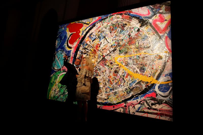 Visitors stand in front of a painting by the British artist Sacha Jafri at the Atlantis hotel in Dubai