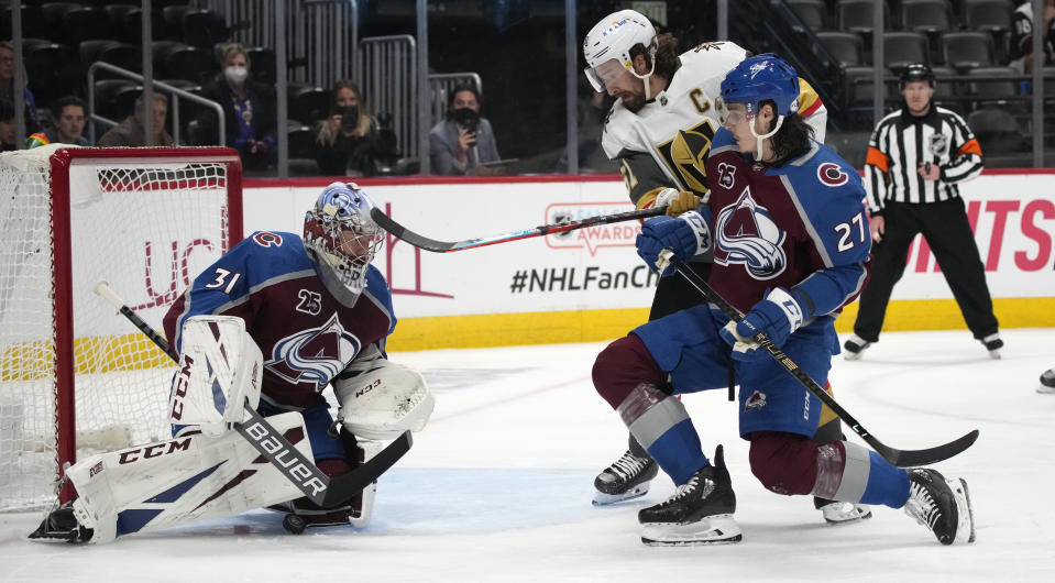 Colorado Avalanche goaltender Philipp Grubauer, left, stops a shot as defenseman Ryan Graves, front right, works against Vegas Golden Knights left wing Max Pacioretty during the first period of Game 5 of an NHL hockey Stanley Cup second-round playoff series Tuesday, June 8, 2021, in Denver. (AP Photo/David Zalubowski)